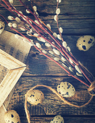 Quail eggs and willow,a symbol of Easter on the aged wooden background.Toned image.Vintage style.selective focus