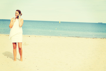Young elegant beautiful woman talking on the phone on the beach