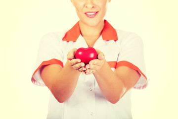 Young female doctor or nurse holding toy heart