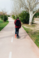Guy moving with his Skate on a Park Path