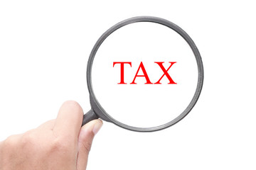 Hand showing Tax word through magnifying glass. Magnifying glass search concept. Isolated on white background.