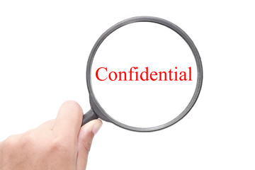Hand showing Confidential word through magnifying glass. Magnifying glass search concept. Isolated on white background.
