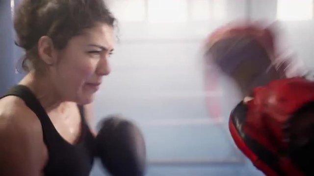 Young woman training with a coach in a boxing club. UHD, 4K.