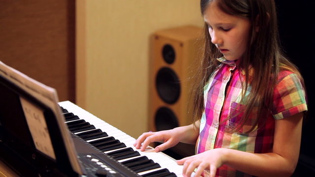 young girl playing on a synthesizer