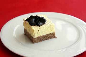slice of decorated with chocolate lemon-chocolate sponge cake, served on white plate
