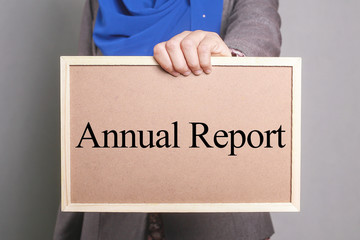 Businesswoman holding a softboard written Annual Report