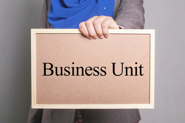 Businesswoman holding a softboard written Business Unit