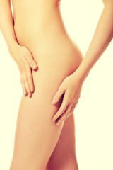 Woman touching her naked thigh