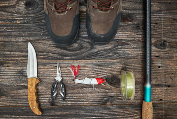 fishing tackles and fishing gear on wooden background