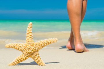 Fototapeta na wymiar Human feet on the wet sand with a starfish.