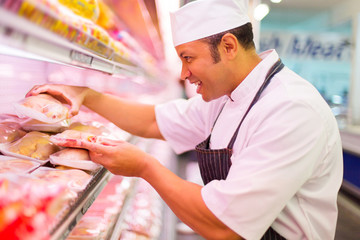 middle aged butcher working in butchery