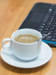 Coffee cup and Laptop on desk