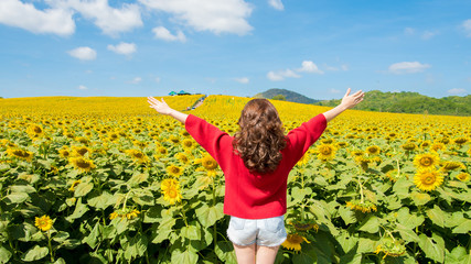 young woman on blooming sunflower field