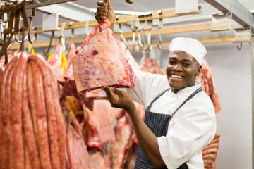 african american butcher handing red meat