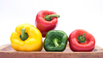 Fresh organic bell peppers on a wooden board