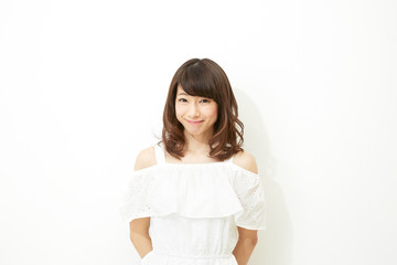 Fototapeta premium ポートレート 白壁の前に立つ女性