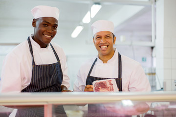 male butchers standing at butchery counter