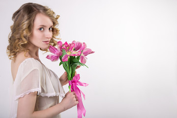 Beautiful blonde spring girl with flowers