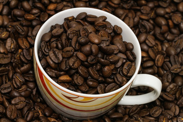 Coffeecup in roasted coffee beans