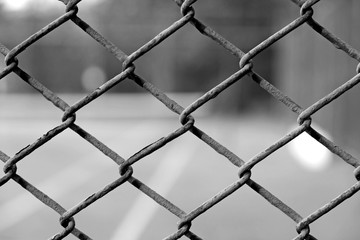 cage of blurred tennis court black and white