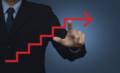 Businessman pointing to red arrow stair symbol on blue backgroun