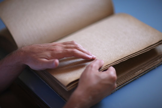 Tactile book for blind readers, hands in focus