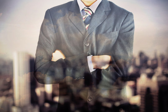 Double exposure of business man body in suit and blurred city
