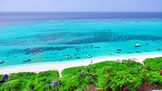 Shoreline of a tropical island in the Maldives and view of the I