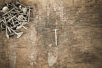 Old grunge rusty nails on vintage wooden background in vintage style