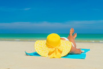 Fototapeta na wymiar Woman in yellow bikini lying on tropical beach