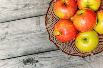 Fresh apples in decorative vase for fruit on wooden table