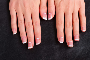 Women's hands with a stylish french manicure.