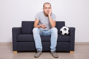 bored soccer fan watching game on tv