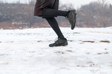 Low section of male runner running on snow. Motion blur.