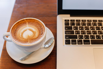 Laptop on Vintage Wooden desktop in modern office with accessori