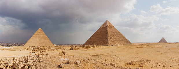 Giza pyramid complex on the background of clouds and Cairo panorama