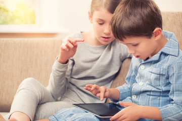 Naklejka premium Children playing with tablet pc