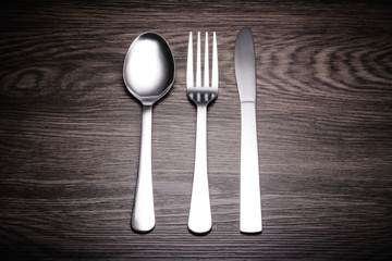 a set of cutlery on wooden background