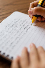 Child writing by hand on notepad