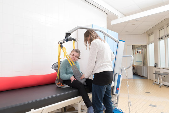 Disability a disabled child being cared for / Disability a disabled child being cared for by a special needs carer using specialist lifting equipment