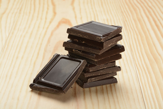Trozos de chocolate apilados sobre fondo de madera