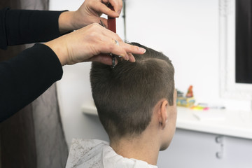 Young man man having a haircut with scissors