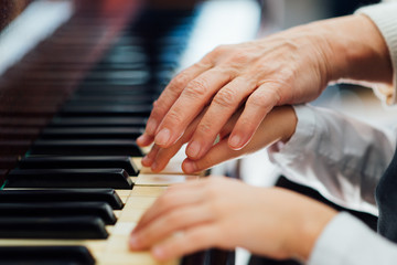 experienced master piano hand helps the student