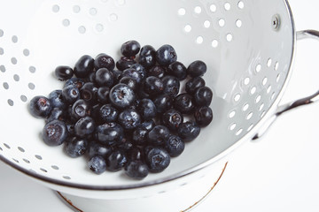 Heap of blueberries in old enamel stainer side