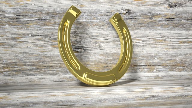 Golden horseshoe, set on wooden surface