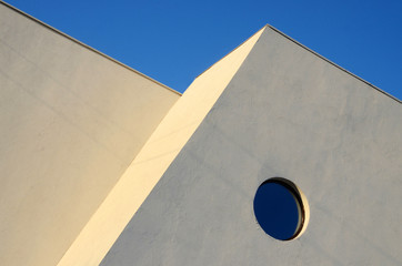 Architecture abstract wall with round window on blue sky 