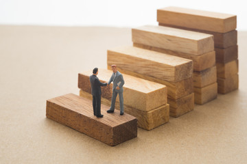Businessmen checking hand on first step of wood stair