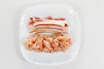 raw chicken and bacon meat on white plate