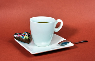 cup of coffee and spoon on white plate.