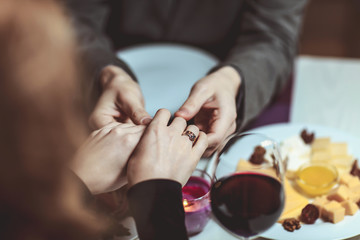 Beautiful young couple with glasses of red wine in luxury restaurant